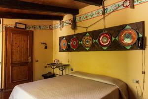 a bedroom with a bed and plates on the wall at Agriturismo Mezzaluna in Málchina