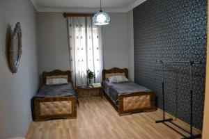 a bedroom with two beds and a window at Guest house Amazon in Kutaisi