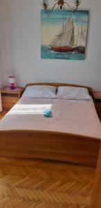 a bed with a wooden frame with a sail boat on it at Apartman Lorena in Stari Grad +7 photos