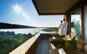 - un couple debout sur le balcon d'un immeuble dans l'établissement Maistra Select All Suite Island Hotel Istra, à Rovinj