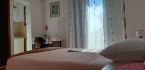 a bedroom with a bed and a large window at Apartman Lorena in Stari Grad