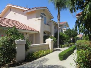 uma casa com uma palmeira e um passeio em Garden Inn and Suites Fresno em Fresno