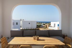 a table and chairs in a room with a large window at TinosVillages in Tinos