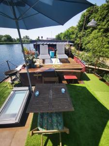 un patio con una mesa y una sombrilla en un barco en Le grand large, en Metz