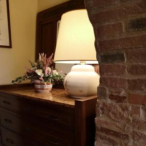 a lamp on a dresser with flowers on it at Sant'Antonio Country Resort in Montepulciano