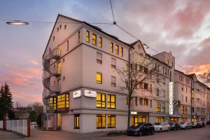 een hoog wit gebouw met gele ramen op een straat bij acora Karlsruhe Zentrum Living the City in Karlsruhe