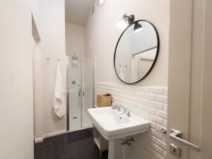 biała łazienka z umywalką i lustrem w obiekcie Gualchierina apartment w mieście Prato