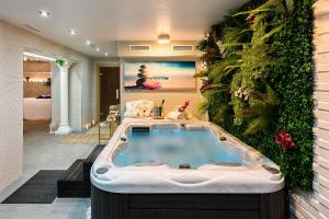 
a bath room with a tub and a pool at El Tiburon Boutique Hotel & Spa (Adults Recommended) in Torremolinos
