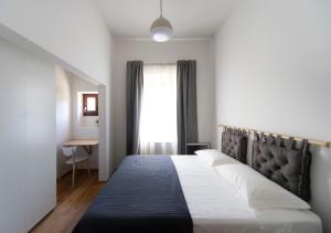 sypialnia z łóżkiem z czarnym zagłówkiem i oknem w obiekcie Gualchierina apartment w mieście Prato