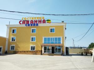 a yellow building with a sign for a car rental center at Savanna in Ryazan