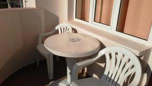 a table and two chairs sitting next to a window at Guest House Malkata Stopanka in Primorsko