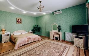 a bedroom with green walls and a bed and a flat screen tv at Grand Hotel in Tambov