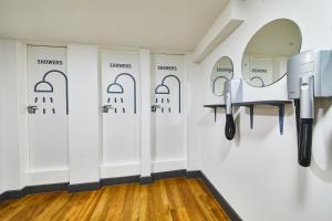 
a bathroom with a white wall and a black and white wall at St Christopher's Inn Village - London Bridge in London
