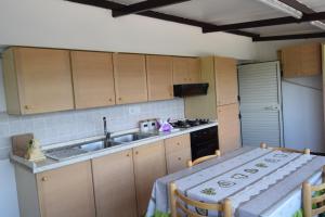 a kitchen with a table and a sink and a stove at B&B La terrazza in Montalbano Elicona