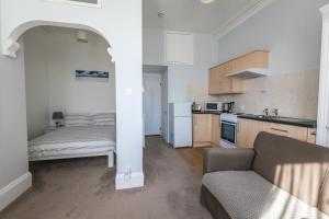 Una sala de estar con un sofá y una cocina. en Clydesdale Apartments, en Torquay