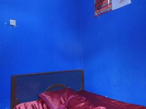 Habitación azul con cama y pared azul en Amora Homestay, en Masbagik