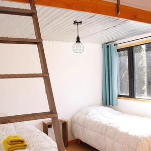 1 dormitorio con 2 literas y escalera en Casas Chaura en El Bolsón