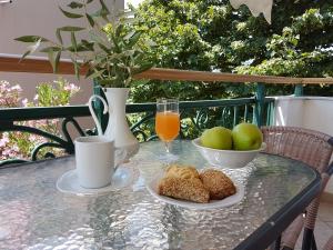 einen Tisch mit einer Schüssel Brot und einem Glas Orangensaft in der Unterkunft Lina Studios in Potos