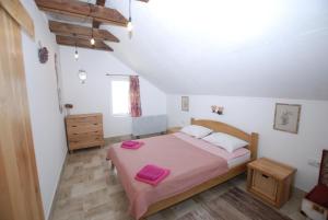 a bedroom with a large bed with pink sheets at Apartment Cats in Donji Milanovac