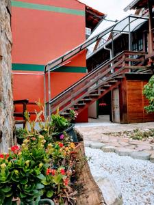 un edificio rojo con escaleras y flores delante en Pousada Vila D' Itália, en Penha