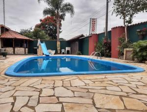 una piscina en un patio con un patio de piedra en Pousada Vila D' Itália, en Penha