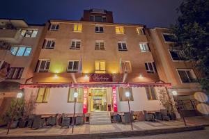 a building with tables and chairs in front of it at Victoria Hotel in Varna City