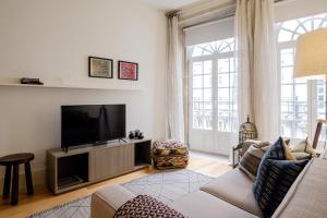 uma sala de estar com um sofá e uma televisão em BOUTIQUE Rentals-Flores Plaza in city historical center no Porto