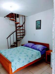 1 dormitorio con 1 cama y escalera de caracol en Pousada Vila D' Itália, en Penha