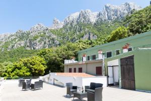 a building with chairs and mountains in the background at S'Enis Monte Maccione in Oliena