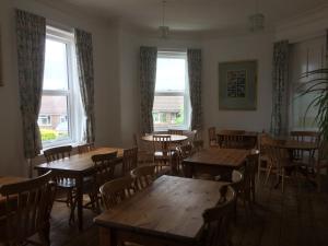 a dining room with tables and chairs and windows at YHA Isle of Wight Totland - Partner in Totland