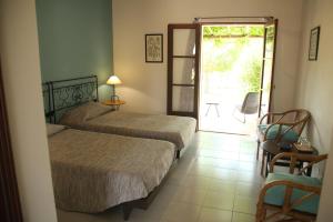 シルヴェスにあるQuinta do Rio Country Innのベッドルーム1室(ベッド2台付)、パティオへのドアが備わります。