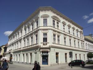 a large white building on the corner of a street at Palace - Belvárosi Apartman Eger in Eger