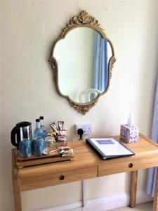 einen Spiegel an einer Wand über einem Holztisch in der Unterkunft The Burrows Bed and Breakfast in Pembroke
