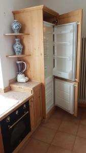 a kitchen with an open refrigerator and a stove at Alisea Home in Pinzolo +24 photos