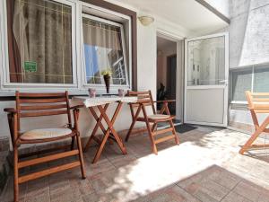 a porch with a table and chairs and a window at Vila Kosta City Center Port in Ohrid +57 photos