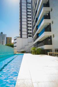 a swimming pool in front of a building at Conforto E Localizacao in Salvador