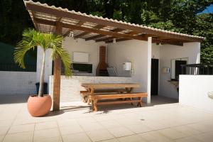 a wooden picnic table and a bench on a patio at Conforto E Localizacao in Salvador