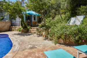 un patio trasero con piscina y una casa en Casa Granada at Masia Nur Sitges, with private pool and adults only, en Canyelles