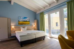 a bedroom with a bed and a large window at Landhaus Himmelpfort am See in Fürstenberg