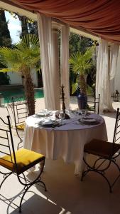 佩爾蒂伊的住宿－La Villa Majorelle，一张带白色桌布和椅子的桌子以及一张带眼镜的桌子