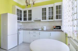 eine Küche mit weißen Schränken und einem weißen Kühlschrank in der Unterkunft Rest Home in Sumy