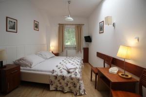 a bedroom with a bed and a desk and a table sidx sidx sidx at Villa Zosieńka in Gdańsk