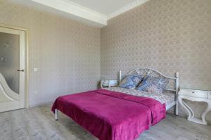 ein Schlafzimmer mit einem großen Bett mit einer lila Decke in der Unterkunft Rest Home in Sumy