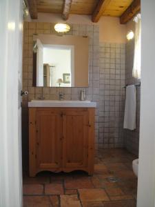 La salle de bains est pourvue d'un lavabo et d'un miroir. dans l'établissement STONE ROSE VILLA, à Ágios Ioánnis