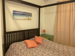 a bedroom with a bed with two orange pillows at SXM Spotters Paradise in Lowlands
