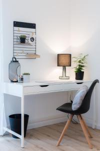 a white desk with a chair and a lamp at Holiday Appartement »Achalm« mit Sonnenterrasse in Reutlingen