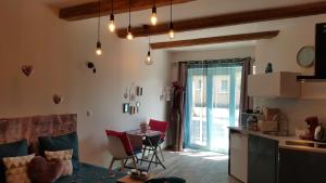 ein Wohnzimmer mit einer Küche und einem Tisch mit Stühlen in der Unterkunft Le Mas Romantique avec Jacuzzi et Sauna privé in Sénas