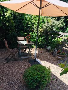 um guarda-chuva sentado ao lado de uma mesa e uma cadeira em Cherrybrook em Glastonbury