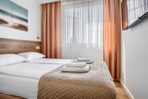 ein Hotelzimmer mit einem Bett mit Handtüchern darauf in der Unterkunft Apartament przy Plaży / Klifowa in Rewal