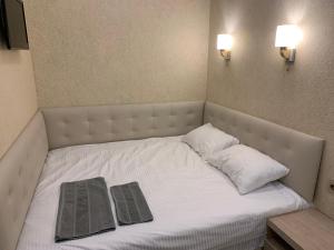 a bed with two pillows and two books on it at Loft Batumi in Batumi